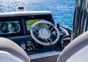 Cockpit of 2022 Pearl 62 yacht with navigation screens and steering wheel.