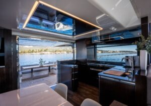 Luxurious interior of 2022 Pearl 62 yacht with modern kitchen and scenic ocean view.