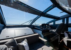 Luxurious interior of 2022 Pearl 62 yacht with panoramic windows and modern helm.