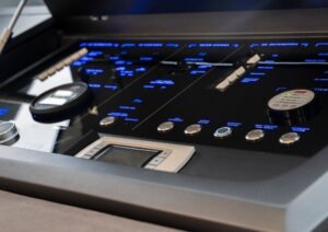 Control panel of a 2022 Pearl 62 yacht with illuminated buttons and displays.