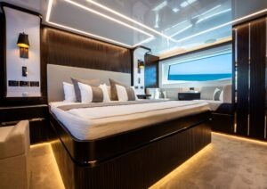 Luxurious bedroom interior on 2022 Pearl 62 yacht with ocean view window.