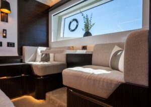 Luxurious interior of 2022 Pearl 62 yacht with elegant seating and large window view.