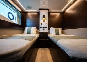 Luxurious twin cabin interior on 2022 Pearl 62 yacht, featuring modern design and ambient lighting.