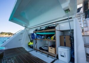 Open storage compartment on 2022 Pearl 62 yacht, filled with water sports equipment.