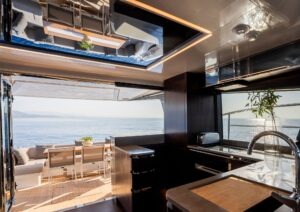 Luxurious interior of 2023 Pearl 62 yacht with ocean view and modern kitchen.