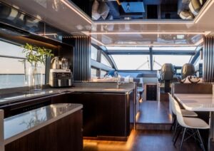 Luxurious interior of 2023 Pearl 62 yacht with modern kitchen and seating area.