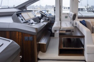 Luxurious helm station of 2021 Sunseeker Manhattan 68 yacht with modern controls and seating.