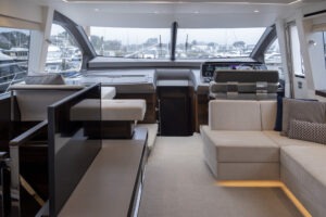 Luxurious interior of 2021 Sunseeker Manhattan 68 yacht with modern seating and helm.