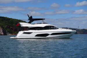 2021 Sunseeker Manhattan 68 yacht on calm sea under blue sky.