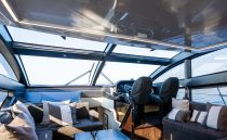 Luxurious interior of 2023 Pearl 62 yacht with modern seating and panoramic windows.