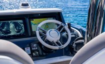 Cockpit of 2022 Pearl 62 yacht with navigation screens and steering wheel.