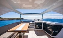 Luxurious 2022 Pearl 62 yacht interior with ocean view, featuring sleek seating and modern design.