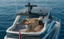 Luxurious 2023 Pearl 62 yacht with spacious deck and elegant seating on calm waters.
