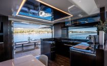 Luxurious interior of 2022 Pearl 62 yacht with modern kitchen and scenic ocean view.