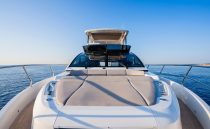 Luxurious 2023 Pearl 62 yacht cruising on calm blue waters under clear skies.