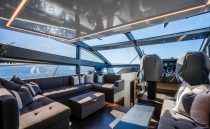 Luxurious interior of 2022 Pearl 62 yacht with panoramic windows and plush seating.