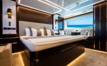 Luxurious bedroom interior on 2022 Pearl 62 yacht with ocean view window.