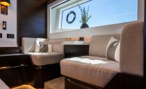 Luxurious interior of 2022 Pearl 62 yacht with elegant seating and large window view.