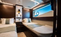 Luxurious 2022 Pearl 62 yacht cabin with twin beds and modern decor.