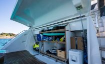 Open storage compartment on 2022 Pearl 62 yacht, filled with water sports equipment.
