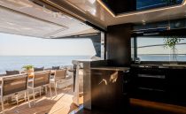 Luxurious Pearl 62 yacht interior with ocean view, featuring modern dining and kitchen area, 2023 model.