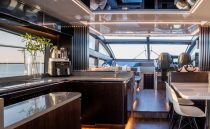 Luxurious interior of 2023 Pearl 62 yacht with modern kitchen and seating area.