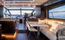 Luxurious interior of 2023 Pearl 62 yacht with modern dining and seating area.