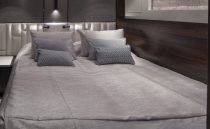 Luxurious bedroom interior of 2021 Sunseeker Manhattan 68 yacht, featuring modern design and cozy bedding.