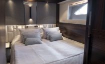 Luxurious bedroom interior of 2021 Sunseeker Manhattan 68 yacht, featuring modern design and cozy bedding.