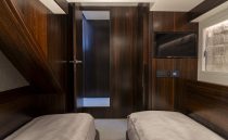 Luxurious cabin interior of 2021 Sunseeker Manhattan 68 yacht with twin beds and TV.