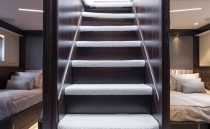 Interior staircase of 2021 Sunseeker Manhattan 68 yacht, leading to luxurious bedrooms.