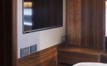 Luxurious interior of 2021 Sunseeker Manhattan 68 yacht with sleek wood paneling and modern TV.