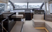 Luxurious interior of 2021 Sunseeker Manhattan 68 yacht with modern seating and helm.