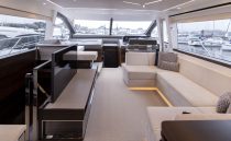 Luxurious interior of 2021 Sunseeker Manhattan 68 yacht with modern seating and large windows.