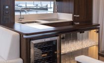 Luxurious kitchen area in 2021 Sunseeker Manhattan 68 yacht with modern cabinetry and glass storage.