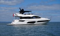 Luxury 2021 Sunseeker Manhattan 68 yacht on calm ocean waters under blue sky.